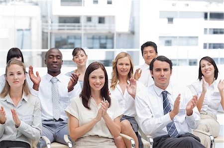 simsearch:6109-06007215,k - A group of colleagues look ahead and applaud as they sit next to each other Stock Photo - Premium Royalty-Free, Code: 6109-06007212