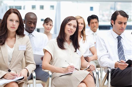 simsearch:6109-06007351,k - Serious colleagues using writing on notepads while they are sitting together Stock Photo - Premium Royalty-Free, Code: 6109-06007218