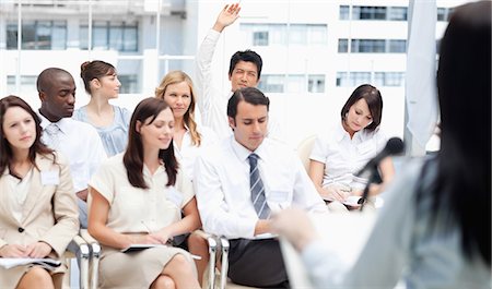 simsearch:6109-06007215,k - Businessman raising his hand while as he is watching a speech while sitting in a group of his colleagues Stock Photo - Premium Royalty-Free, Code: 6109-06007232