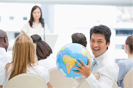 people with globe - Man laughing as he holds a globe in his hands during a speech Stock Photo - Premium Royalty-Free, Code: 6109-06007327