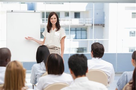 Brunette businesswoman giving a presentation to her colleagues while using a chart Stock Photo - Premium Royalty-Free, Code: 6109-06007330