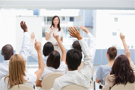 Audience raising their hands above their head while watching a businesswoman Foto de stock - Sin royalties Premium, Código: 6109-06007336