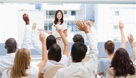 female raising her hand - Audience watch a businesswoman as they raise their arms above their head Stock Photo - Premium Royalty-Free, Code: 6109-06007338