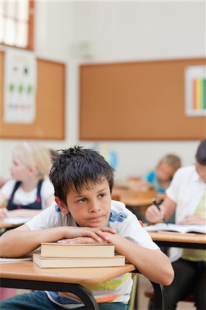 Sad looking elementary student in class Foto de stock - Sin royalties Premium, Código: 6109-06007449