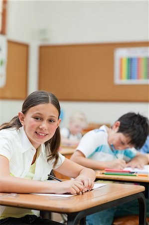 simsearch:6109-06007437,k - Side view of smiling elementary student sitting at her desk Stock Photo - Premium Royalty-Free, Code: 6109-06007461