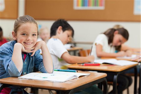 simsearch:6109-06007422,k - Vue latérale d'un heureux jeune écolière au cours de la classe Photographie de stock - Premium Libres de Droits, Code: 6109-06007467