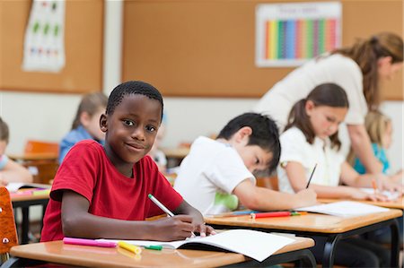 simsearch:6109-06007611,k - Vue latérale d'élèves du primaire souriants au cours de la classe Photographie de stock - Premium Libres de Droits, Code: 6109-06007474