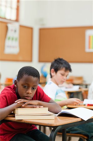 simsearch:6109-06007545,k - Bored elementary student leaning on a stack of books Foto de stock - Sin royalties Premium, Código: 6109-06007479