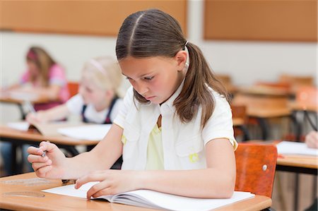 Elementary student working on her exercise book Stock Photo - Premium Royalty-Free, Code: 6109-06007417