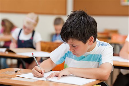 Primary student focused on his exercise book Foto de stock - Sin royalties Premium, Código: 6109-06007427