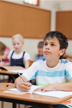 student thinking in a classroom - Primary student listening to his teacher Foto de stock - Sin royalties Premium, Código: 6109-06007429