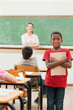 simsearch:6109-06007545,k - Smiling elementary student with his exercise book in class Foto de stock - Sin royalties Premium, Código: 6109-06007546