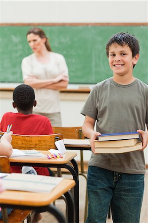 Smiling boy with stack of books Stock Photo - Premium Royalty-Free, Code: 6109-06007558