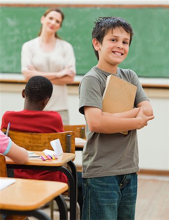 students at desk - Smiling little boy holding book Stock Photo - Premium Royalty-Free, Code: 6109-06007560