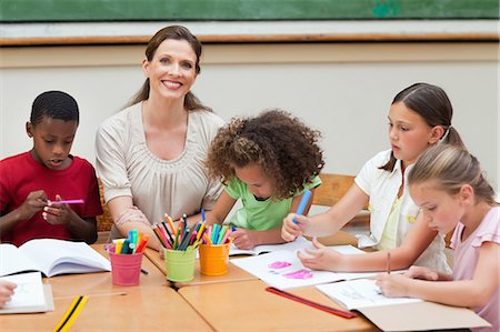 Smiling elementary teacher paining together her students Stock Photo - Premium Royalty-Free, Code: 6109-06007583