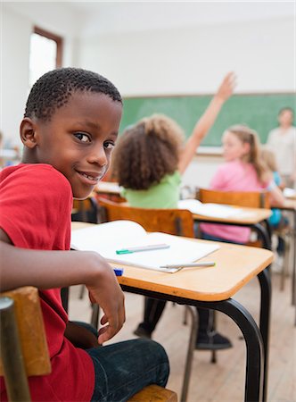 pencil (writing instrument) - Smiling elementary student turned around in class Foto de stock - Sin royalties Premium, Código: 6109-06007517