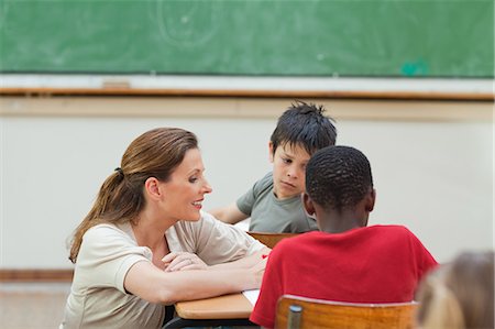 Elementary teacher helping one of her students with exercises Stock Photo - Premium Royalty-Free, Code: 6109-06007531