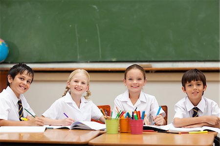 Écoliers peu souriants assis au comptoir Photographie de stock - Premium Libres de Droits, Code: 6109-06007617