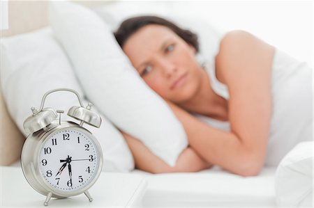Alarm clock with a woman who just wakes up Stock Photo - Premium Royalty-Free, Code: 6109-06194163
