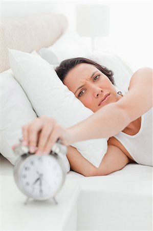 simsearch:400-04335052,k - Close-up of a young woman in her bed turning off her alarm clock Foto de stock - Sin royalties Premium, Código: 6109-06194170