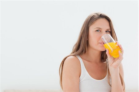 Pretty woman drinking an orange juice Stock Photo - Premium Royalty-Free, Code: 6109-06194434