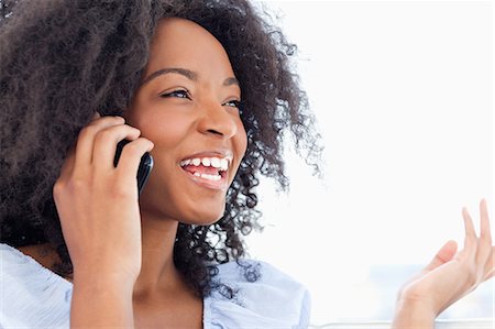 Close-up of a woman with fuzzy hair chatting on the phone Stock Photo - Premium Royalty-Free, Code: 6109-06194560