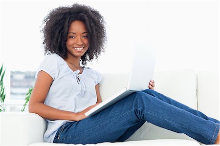 Portrait d'une femme souriante de cheveux crépus avec un ordinateur portable Photographie de stock - Premium Libres de Droits, Code: 6109-06194582