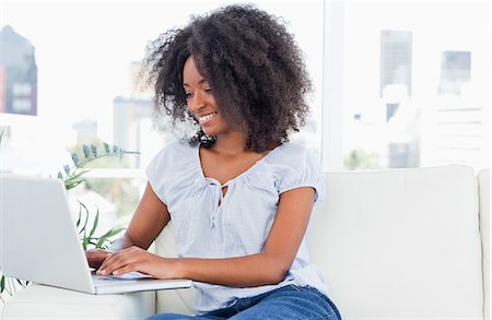 Fuzzy hair woman tapping on her laptop Foto de stock - Sin royalties Premium, Código: 6109-06194595