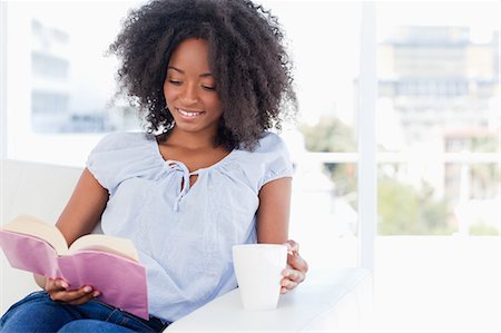 woman holding a cup and reading a book Stock Photo - Premium Royalty-Free, Code: 6109-06194689