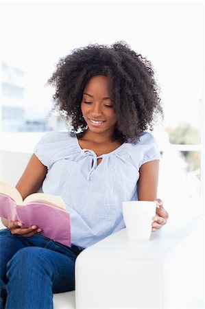 Close-up of a woman holding a cup and reading a novel Stock Photo - Premium Royalty-Free, Code: 6109-06194690