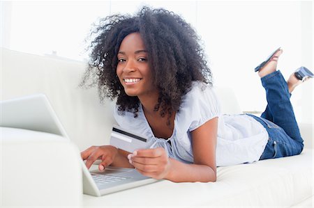 Portrait of a smiling fuzzy hair woman using her credit card Foto de stock - Sin royalties Premium, Código: 6109-06194623