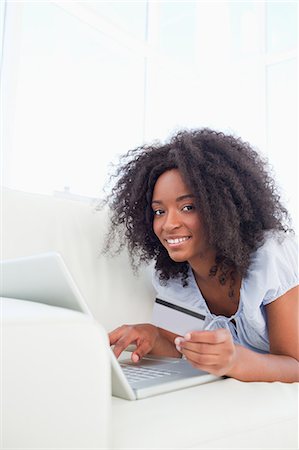 simsearch:6109-06194554,k - Portrait of a smiling fuzzy hair woman buying on the internet Stock Photo - Premium Royalty-Free, Code: 6109-06194624