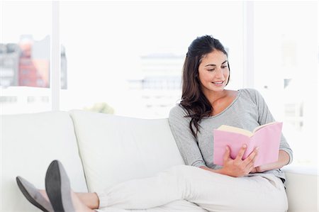 sofa - Smiling woman with a novel Stock Photo - Premium Royalty-Free, Code: 6109-06194840