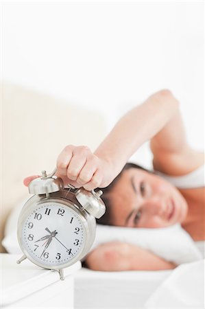 pillow close up - Brunette hating her alarm Stock Photo - Premium Royalty-Free, Code: 6109-06194894