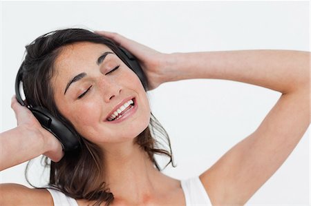 people music white background - Close-up of a happy brunette listening to music Stock Photo - Premium Royalty-Free, Code: 6109-06194965