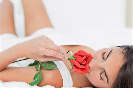 face with rose - Brunette lying on her back while smelling a rose Stock Photo - Premium Royalty-Free, Code: 6109-06194987