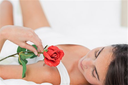 face with rose - Brunette lying on her back with a rose Stock Photo - Premium Royalty-Free, Code: 6109-06194986