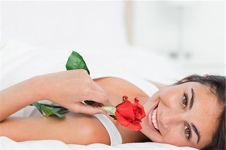 Portrait of a beauty lying on her back while holding a rose Fotografie stock - Premium Royalty-Free, Codice: 6109-06194992