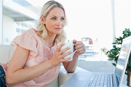 Blonde on a laptop with a hot chocolate Stock Photo - Premium Royalty-Free, Code: 6109-06195057