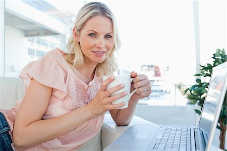 shopping at home - Portrait of a blonde on a laptop with a coffee Stock Photo - Premium Royalty-Free, Code: 6109-06195056