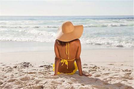 straw beach - Rear view of a young woman looking at the ocean Stock Photo - Premium Royalty-Free, Code: 6109-06195298