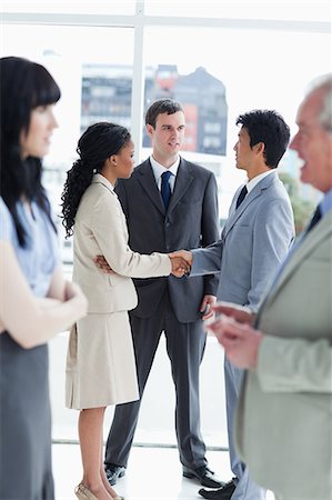 Two executives shaking hands and speaking to another man Foto de stock - Sin royalties Premium, Código: 6109-06195223