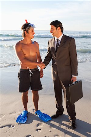 smile of shake hands - Young men shaking hands on the beach Foto de stock - Sin royalties Premium, Código: 6109-06195376