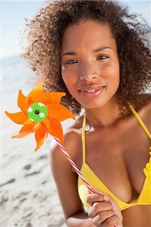 Young attractive woman looking at the camera while holding a pinwheel Stock Photo - Premium Royalty-Free, Code: 6109-06195310