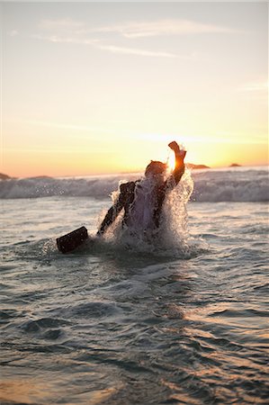 people walking on the beach sunset - Young businessman getting in the water Stock Photo - Premium Royalty-Free, Code: 6109-06195408