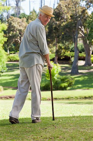 seniors walking alone - Old man with walking stick and hat looking back at camera Stock Photo - Premium Royalty-Free, Code: 6109-06195431