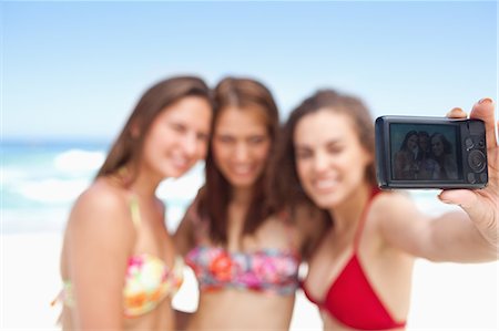 smiling friends taking picture together - Three friends posing for a photo Stock Photo - Premium Royalty-Free, Code: 6109-06195550