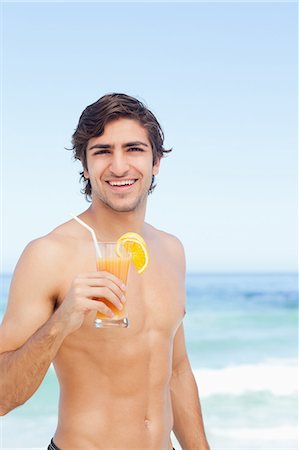 simsearch:6109-06195501,k - Man looking ahead and smiling while holding a cocktail Stock Photo - Premium Royalty-Free, Code: 6109-06195503