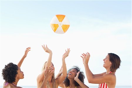 Quatre amis jettent un ballon de plage vers le haut Photographie de stock - Premium Libres de Droits, Code: 6109-06195624