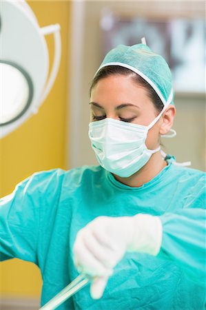 Concentrated female surgeon using surgical tools Foto de stock - Sin royalties Premium, Código: 6109-06195798